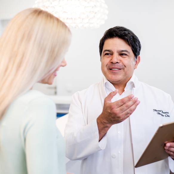 Ein Arzt erläutert einer blonden Patientin die weiteren Optionen für die Behandlung.