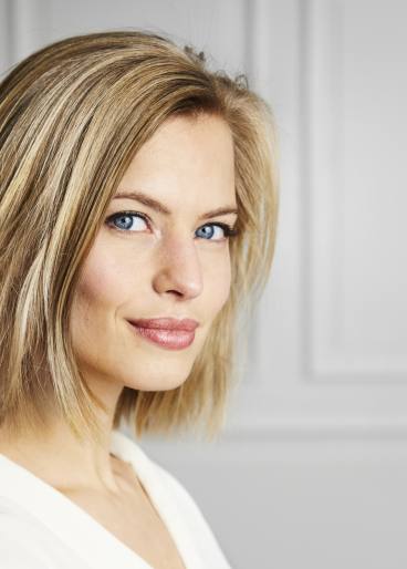 Schöne, dunkelblonde Frau, zufrieden, nach einer Gesichtsbehandlung.