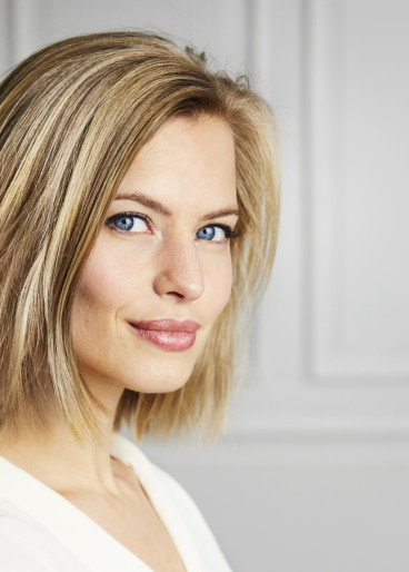 Schöne, dunkelblonde Frau, zufrieden, nach einer Gesichtsbehandlung.