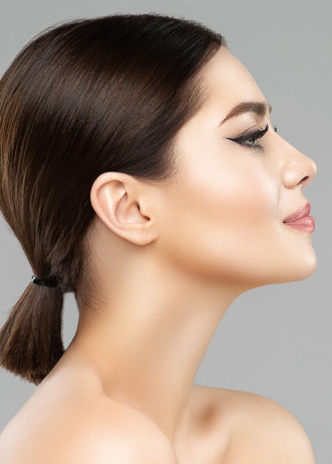 Dunkelhaarige, junge Frau, mit schönem glatten Hautbild, nach einer Gesichtsbehandlung.